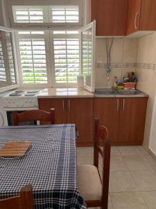 - une cuisine avec une table, une cuisinière et un évier dans l'établissement Anita Guest House, à Tivat