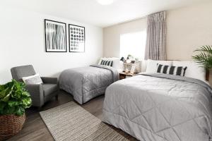 sypialnia z 2 łóżkami i krzesłem w obiekcie InTown Suites Extended Stay Albuquerque NM w Albuquerque