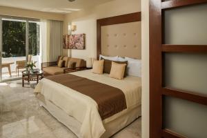 
a bedroom with a large bed and a large window at Grand Riviera Princess - All Inclusive in Playa del Carmen
