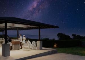 a group of people standing under a gazebo at night at ritomaru villa @ hatsuyama iki in Iki