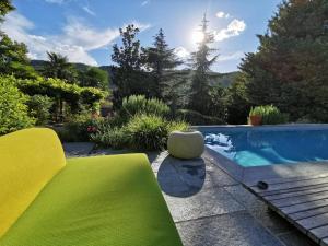 a backyard with a swimming pool and a yellow chair at B&B Casa Percivalle in Borgo Priolo