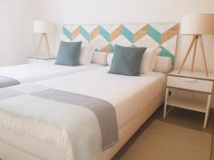 a bedroom with two beds and a table with lamps at Marina Club Lagos Resort in Lagos