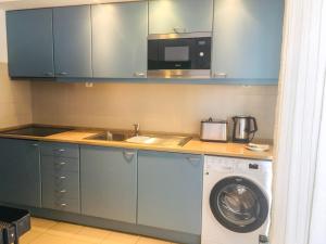a kitchen with a washing machine and a sink at Marina Club Lagos Resort in Lagos
