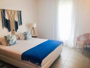a bedroom with a bed with blue sheets and a window at Marina Club Lagos Resort in Lagos