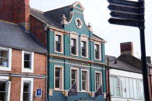 a blue building with a clock on top of it at The Auction House in Morpeth