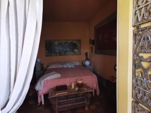 a bedroom with a bed with a table and a window at B&B Casa Percivalle in Borgo Priolo