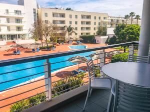 a balcony with tables and chairs and a swimming pool at Marina Club Lagos Resort in Lagos
