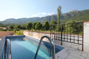 a swimming pool with mountains in the background at Apartment with pool Tomic Boka Bay in Herceg-Novi