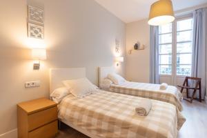 ein Schlafzimmer mit zwei Betten und einem Fenster in der Unterkunft Urbe10 Angel Suites 2 Bedrooms Apartment 2A in Málaga