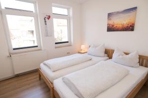 2 camas en una habitación con 2 ventanas en FeWo Engler Wallstraße W4, en Lüneburg
