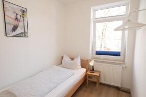 Habitación pequeña con cama y ventana en FeWo Engler Wallstraße W4, en Lüneburg