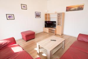 Sala de estar con sofá rojo y mesa de centro en FeWo Engler Wallstraße W4, en Lüneburg