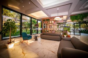 Hotel Corina في فينوس: غرفة معيشة مع أريكة وكراسي ونوافذ كبيرة