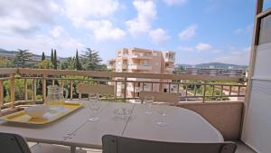 - une table blanche avec des verres à vin sur le balcon dans l'établissement Santa Cruz, à Sainte-Maxime