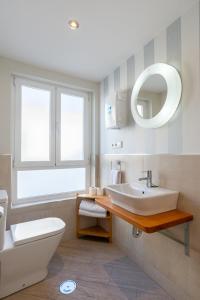 een badkamer met een wastafel, een toilet en een spiegel bij Urbe10 Angel Suites duplex 2 Bedrooms 4C in Málaga