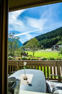 a table on a balcony with a view of a field at Haus Simone in Neustift im Stubaital