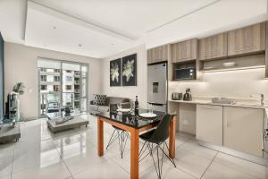 cocina y sala de estar con mesa y sillas en Easy Stay - The Tyrwhitt Rosebank en Johannesburgo