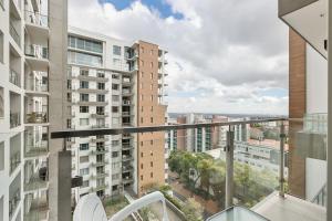 an apartment balcony with a view of buildings at Easy Stay - The Tyrwhitt Rosebank in Johannesburg