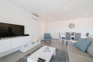 a living room with a couch and a tv at Muralha 2 - Holiday Apartments - By SCH in Nazaré