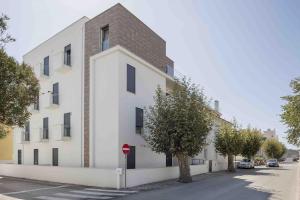 a white building with a red stop sign on a street at Casas do Parque - By SCH in São Martinho do Porto