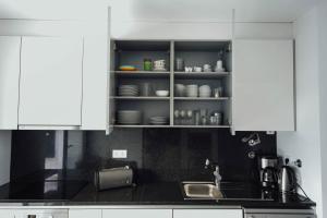 a kitchen with white cabinets and a sink and a counter at Deluxe Villa - By SCH in Salir do Porto