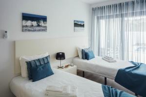 two beds in a room with blue and white at Deluxe Villa - By SCH in Salir do Porto +19 photos