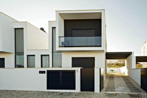 a white house with black windows and a balcony at Deluxe Villa - By SCH in Salir do Porto