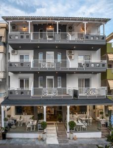 an image of a hotel with tables and chairs at Aqua Mare Hotel in Nea Kallikrateia