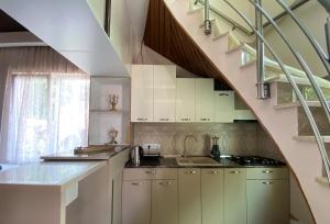 a kitchen with white cabinets and a spiral staircase at PALAZZO in Tbilisi City