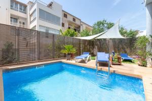una piscina con 2 sillas y una mesa junto a un edificio en NEW! Villa Boutique Mallorca, en Lloseta