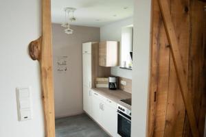 a kitchen with white cabinets and a refrigerator at Ferienwohnung Träwa in Sulzbach