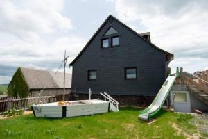 a house with a slide in front of a house at Ferienwohnung Träwa in Sulzbach