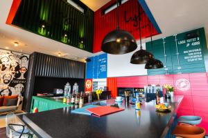 a bar in a restaurant with pink and green walls at lyf Tenjin Fukuoka in Fukuoka