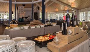 a buffet with white plates and wine bottles and food at Käringsund Resort in Eckerö