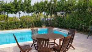 a table and chairs next to a swimming pool at Sinilù B&B in Silvi Paese