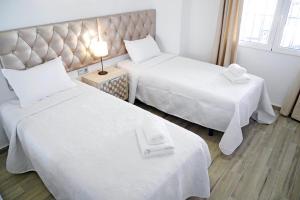 pokój hotelowy z dwoma łóżkami z białymi prześcieradłami w obiekcie Neenies Nerja - Carabeo Luxury Apartment w mieście Nerja +14 zdjęć