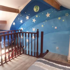 Una habitación infantil con un mural de estrellas y luna. en villa Natacha, en Villeparisis