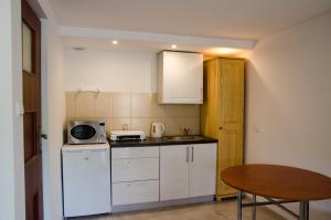 a small kitchen with a table and a microwave at Pod Dębami in Wadowice +25 photos