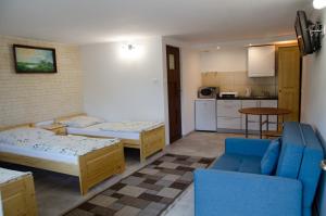 a living room with two beds and a kitchen at Pod Dębami in Wadowice