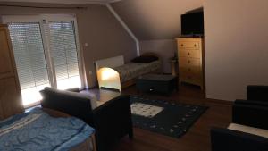 a small living room with a bed and a dresser at Pelso Vendégház in Balatonberény