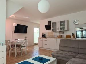 een keuken en woonkamer met een tafel en een bank bij Haus Annelie FEWO 2 OG in Dranske