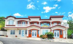 una casa de color naranja y blanco en Discovery Beach Apartments, en Aguada