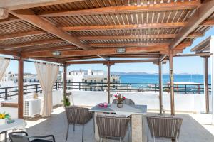 a patio with a table and chairs and the ocean at Rooms Maria in Naxos Chora