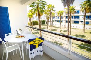 a balcony with a table and chairs and palm trees at Marina Club Lagos Resort in Lagos