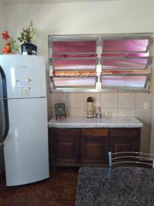 a kitchen with a white refrigerator and a sink at Hostel Nossa Casa in Florianópolis