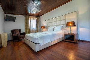a bedroom with a large white bed and a chair at Valonquinta - Agro Hotel & SPA in Vila Flor +77 photos