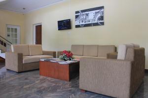 Sala de estar con sofás y mesa de centro en Grand 7 Hotel Thalawathugoda, en Talawatugoda