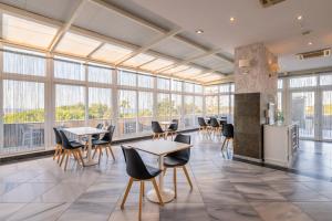 a large room with tables and chairs and windows at Velamar Boutique Hotel - Adults Friendly in Albufeira