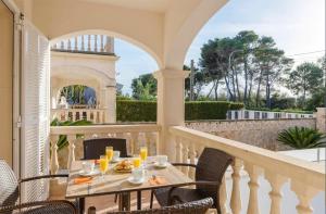 a patio with a table and chairs on a balcony at Benestar Pool and Beach in Platja de Muro in Muro