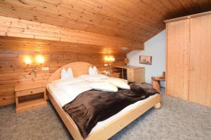 una camera da letto con un grande letto in una camera in legno di Hotel Chalet Olympia a Monguelfo